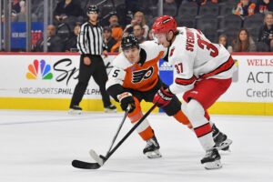 Oct 30, 2023; Philadelphia, Pennsylvania, USA; Philadelphia Flyers defenseman Egor Zamula (5) and Carolina Hurricanes right wing Andrei Svechnikov (37) battle for the puck during the third period at Wells Fargo Center.
