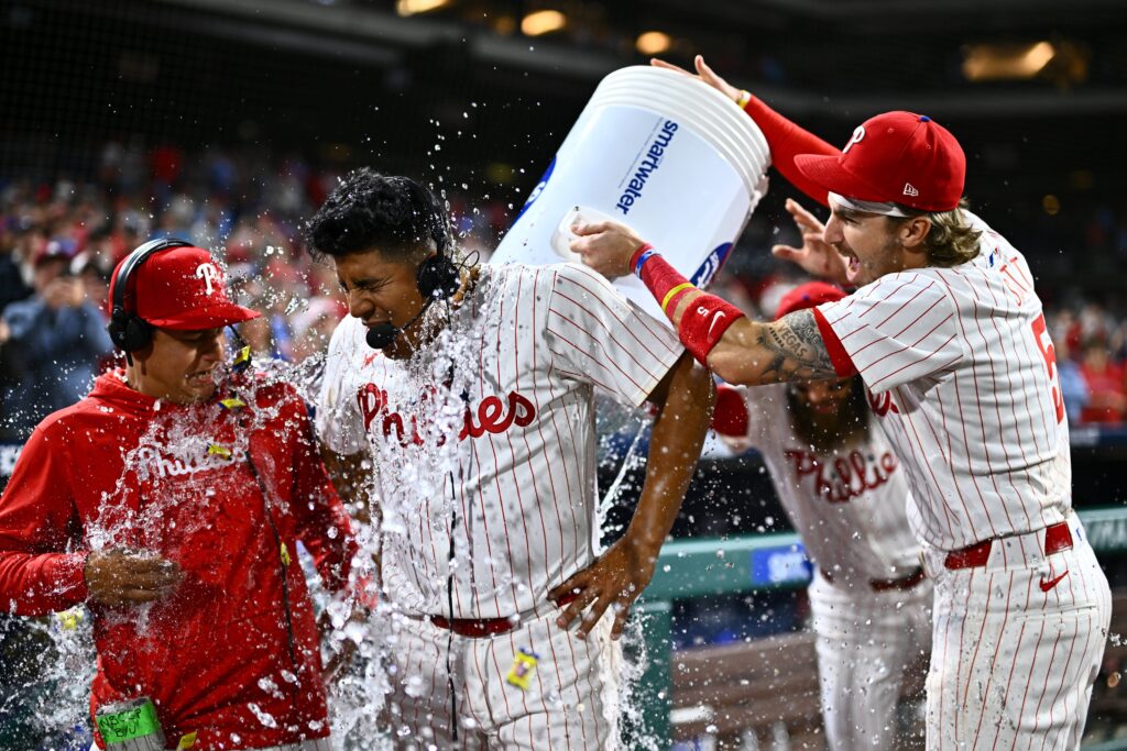 Apr 16, 2024; Philadelphia, Pennsylvania, USA; Philadelphia Phillies starting pitcher Ranger Suarez (55) is showered by second baseman Bryson Stott (5) and outfielder Brandon Marsh (16) after pitching a complete game shutout against the Colorado Rockies at Citizens Bank Park.