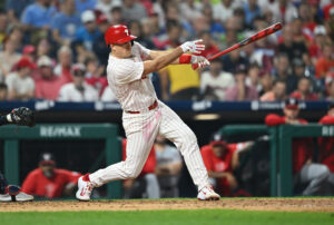 Aug 17, 2024; Philadelphia, Pennsylvania, USA; Philadelphia Phillies catcher J.T. Realmuto (10) hits an RBI single against the Washington Nationals in the sixth inning at Citizens Bank Park.