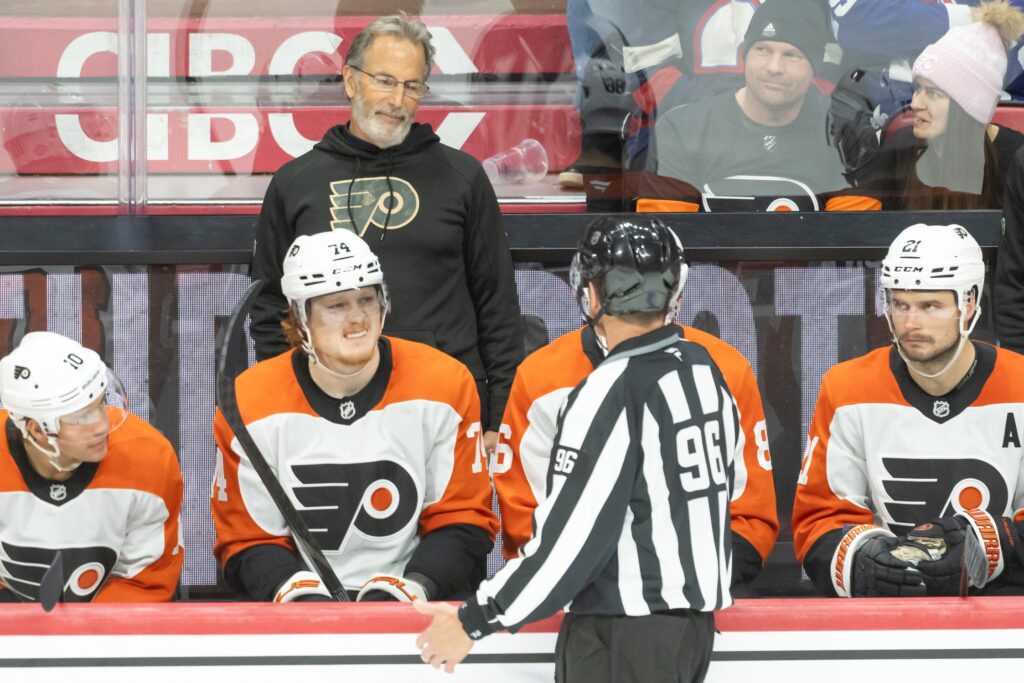 Nov 14, 2024; Ottawa, Ontario, CAN; Philadelphia Flyers head coach John Tortorella speaks with linesperson David Brisebois (96) prior to the start of the second period against the Ottawa Senators at the Canadian Tire Centre.