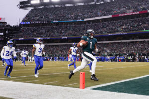 Jan 19, 2025; Philadelphia, Pennsylvania, USA; Philadelphia Eagles quarterback Jalen Hurts (1) runs with the ball to score a touchdown against the Los Angeles Rams during the first half in a 2025 NFC divisional round game at Lincoln Financial Field.