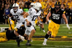Penn State Nittany Lions quarterback Ethan Grunkemeyer (17) scrambles away from Iowa Hawkeyes defensive back Xavier Nwankpa (1) and Iowa Hawkeyes defensive lineman Aaron Graves (95) during a college football game Oct. 18, 2025 at Kinnick Stadium in Iowa City, Iowa.