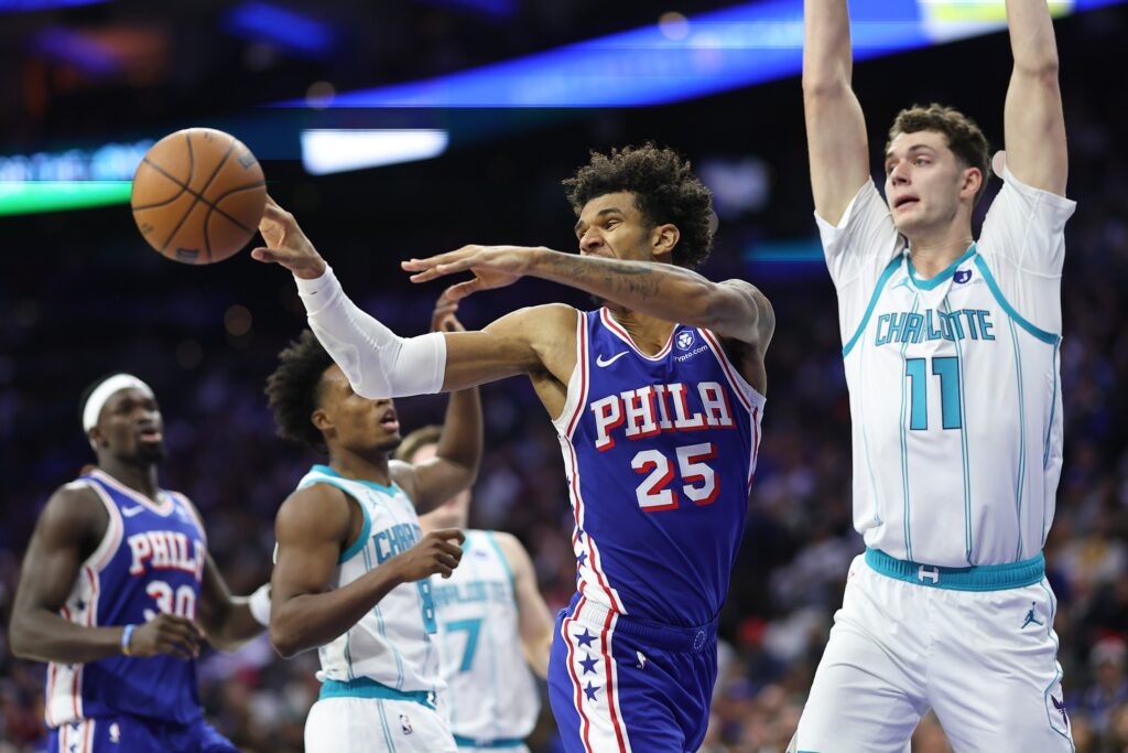 Oct 25, 2025; Philadelphia, Pennsylvania, USA; Philadelphia 76ers forward Dominick Barlow (25) passes the ball in front of Charlotte Hornets center Ryan Kalkbrenner (11) during the second quarter at Xfinity Mobile Arena.