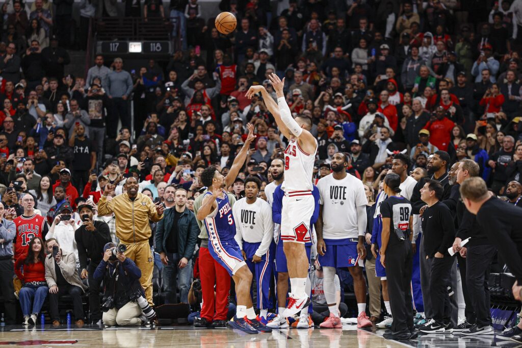 Nov 4, 2025; Chicago, Illinois, USA; Chicago Bulls center Nikola Vucevic (9) shoots and scores a game winning three-pointer against Philadelphia 76ers guard Quentin Grimes (5) during the second half at United Center.