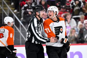 Nov 29, 2025; Newark, New Jersey, USA; Philadelphia Flyers right wing Tyson Foerster (71) is restrained by linesman Julien Fournier (56) during the third period against the New Jersey Devils at Prudential Center.