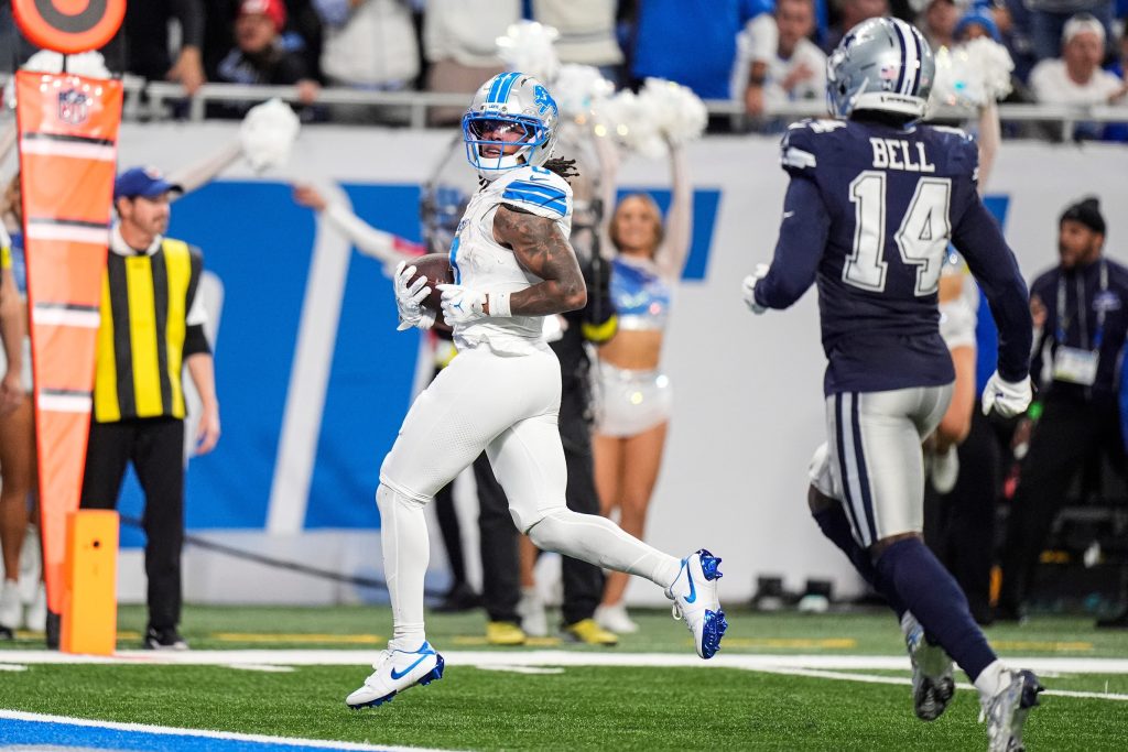 Detroit Lions running back Jahmyr Gibbs (0) runs for a touchdown against Dallas Cowboys safety Markquese Bell (14) during the second half at Ford Field in Detroit on Thursday, Dec. 4, 2025.