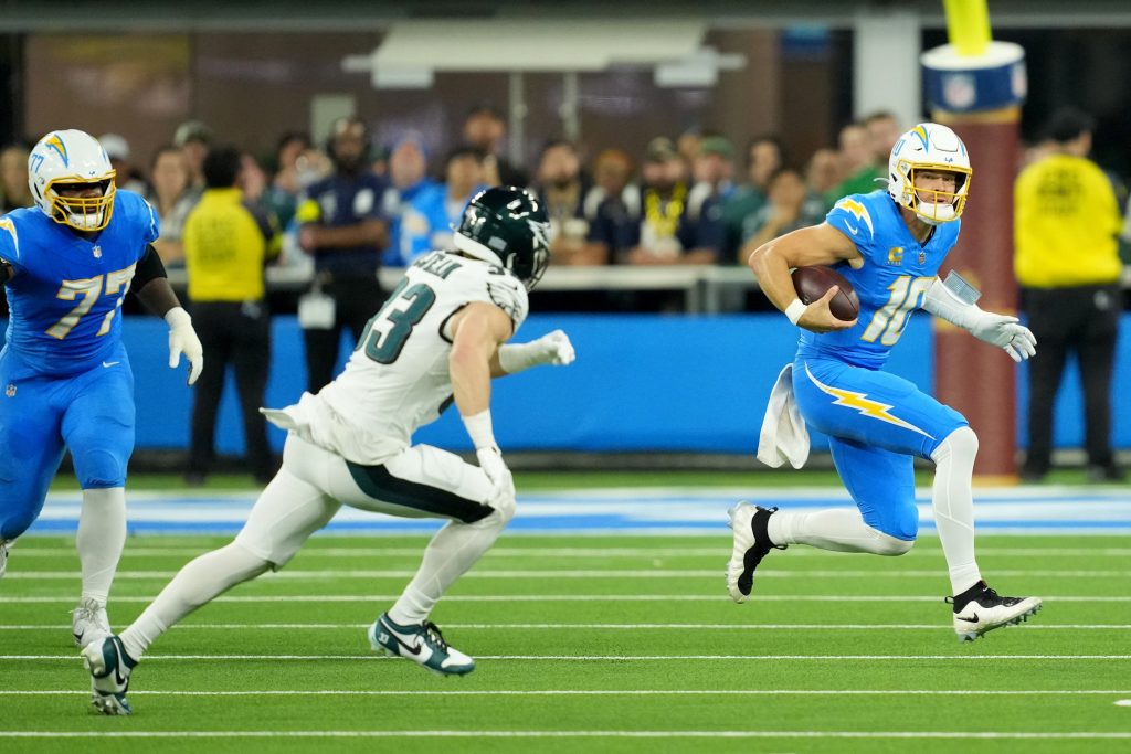 Dec 8, 2025; Inglewood, California, USA; Los Angeles Chargers quarterback Justin Herbert (10) runs against Philadelphia Eagles cornerback Cooper Dejean (33) at SoFi Stadium.