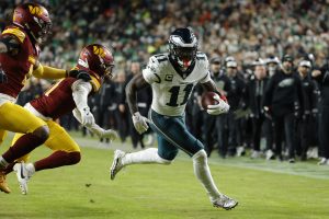Dec 20, 2025; Landover, Maryland, USA; Philadelphia Eagles wide receiver A.J. Brown (11) carries the ball as Washington Commanders cornerback Jonathan Jones (31) and Washington Commanders linebacker Frankie Luvu (4) defend during the first half at Northwest Stadium.