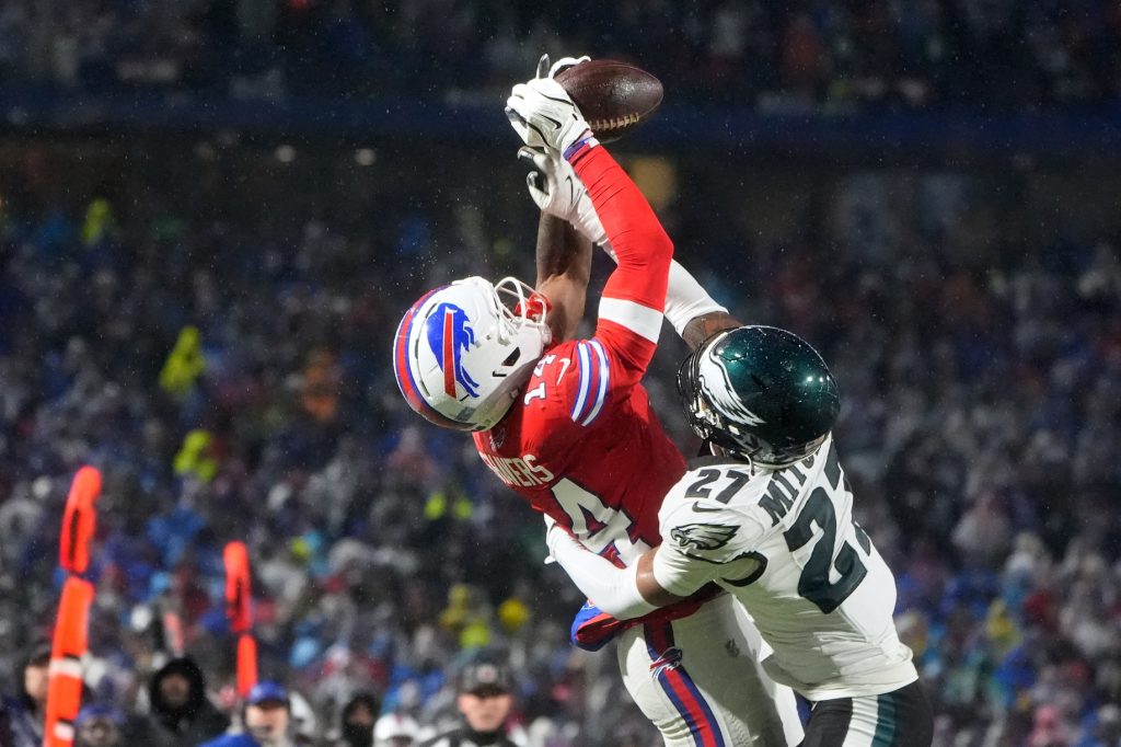 Dec 28, 2025; Orchard Park, New York, USA; Buffalo Bills wide receiver Tyrell Shavers (14) leaps to catch a thirty-two yard pass thrown by quarterback Josh Allen (not pictured) against Philadelphia Eagles cornerback Quinyon Mitchell (27) during the third quarter at Highmark Stadium.