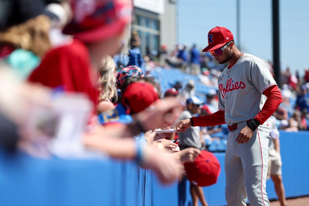 Mar 2, 2025; Dunedin, Florida, USA; Philadelphia Phillies outfielder Justin Crawford (80) signs autographs for fans before a game against the Toronto Blue Jays during spring training at TD Ballpark.