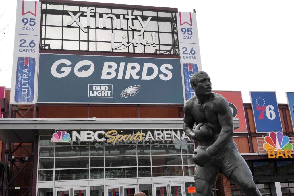 Feb 13, 2025; Philadelphia, PA, USA; A Philadelphia Eagles Bud Light advertisement and statue of boxer Joe Frazier at the NBC Sports Arena Philadelphia - Xfinity Live!