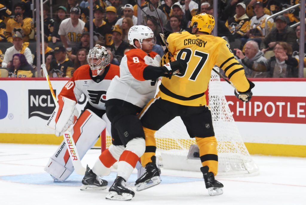 Apr 18, 2026; Pittsburgh, Pennsylvania, USA; Philadelphia Flyers defenseman Cam York (8) checks Pittsburgh Penguins center Sidney Crosby (87) in front of Flyers goaltender Dan Vladar (80) during the first period against in game one of the first round of the 2026 Stanley Cup Playoffs at PPG Paints Arena.
